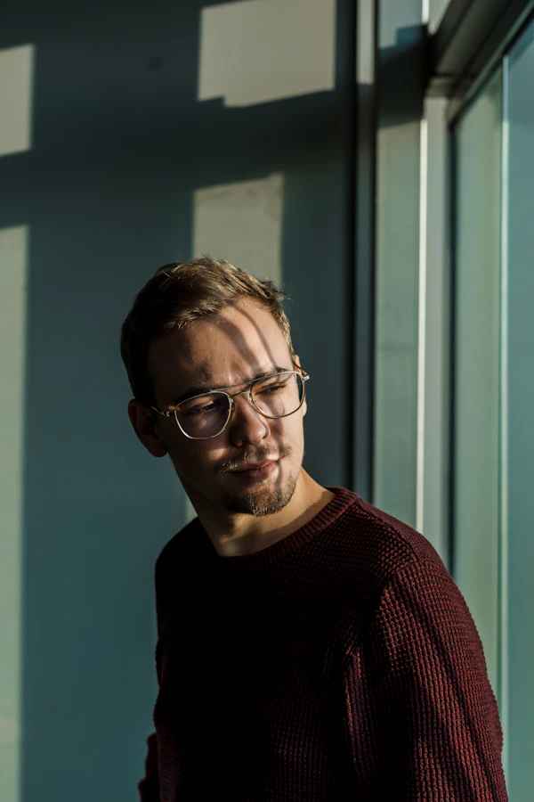 Man in a knit sweater wearing round eyeglasses