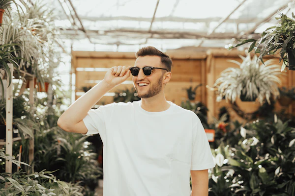 Man in white tee wearing sunglasses among plants