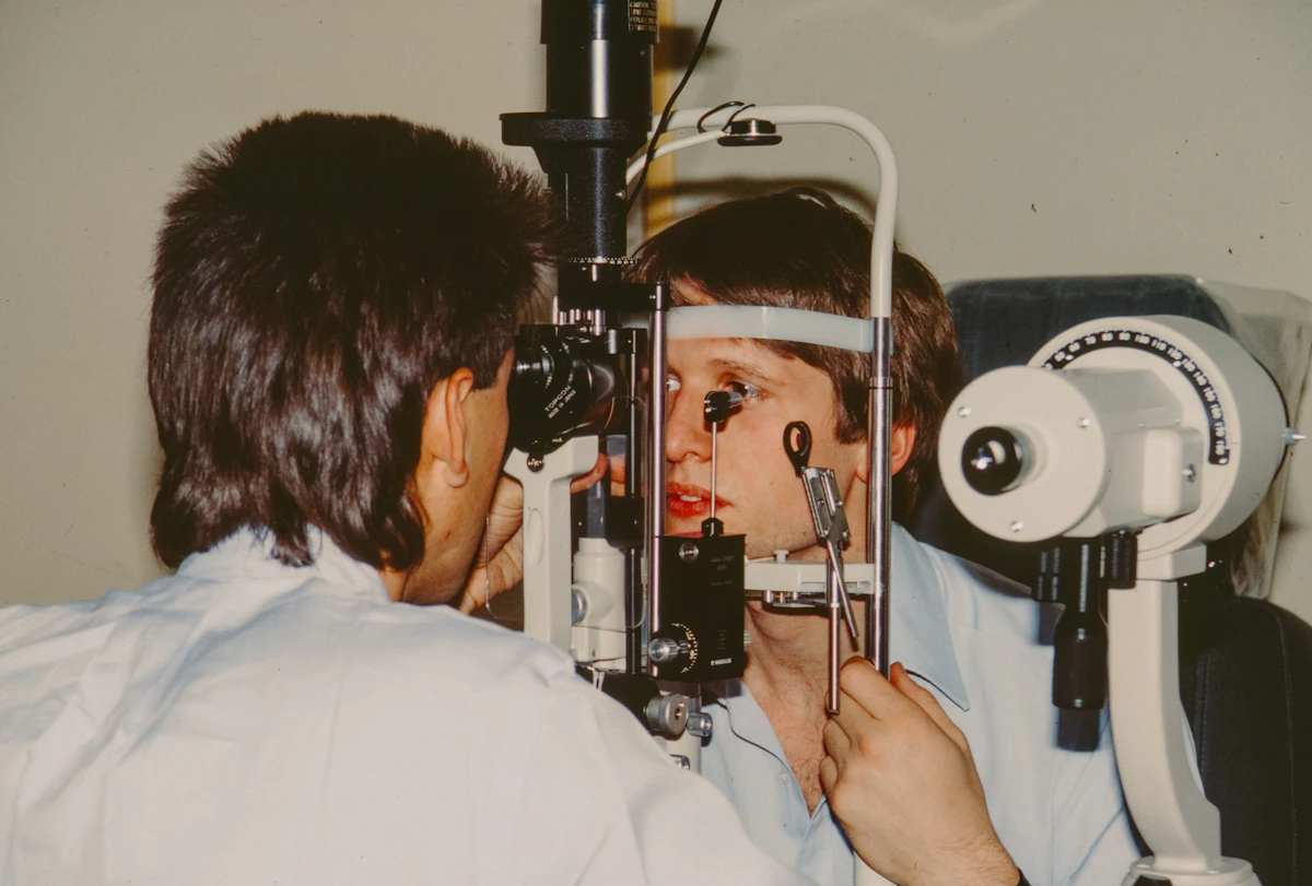 Optometrist examining a patient's eyes with a slit lamp