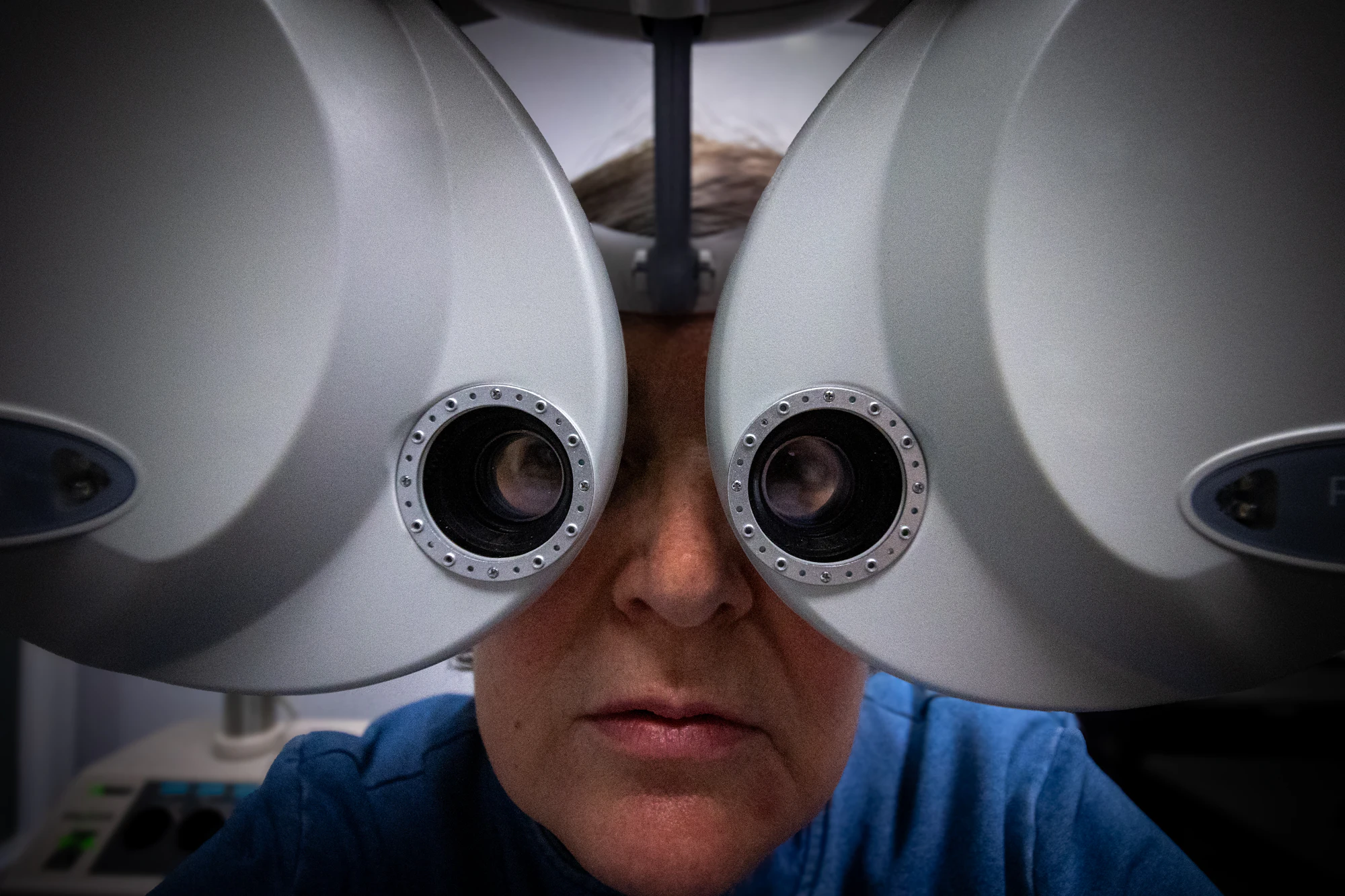 Patient looking through a phoropter during an eye examination