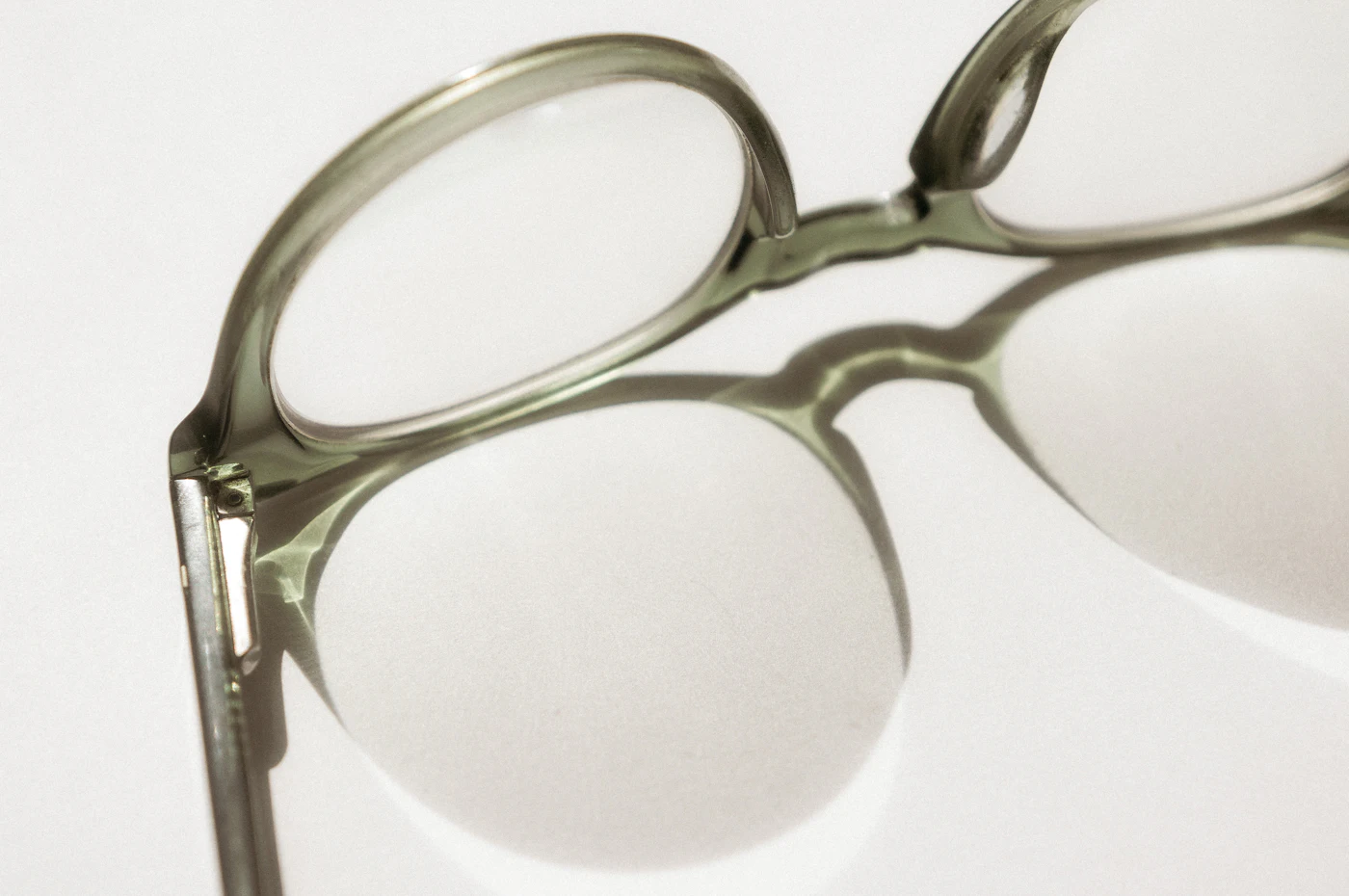 Translucent sage acetate frame casting a soft shadow
