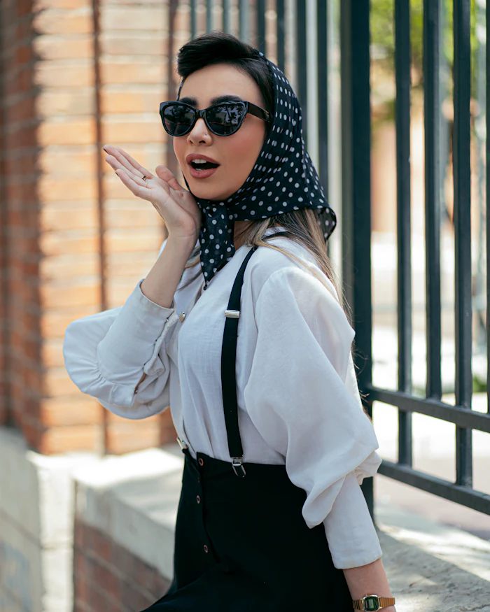 Woman in a polka-dot headscarf wearing black sunglasses