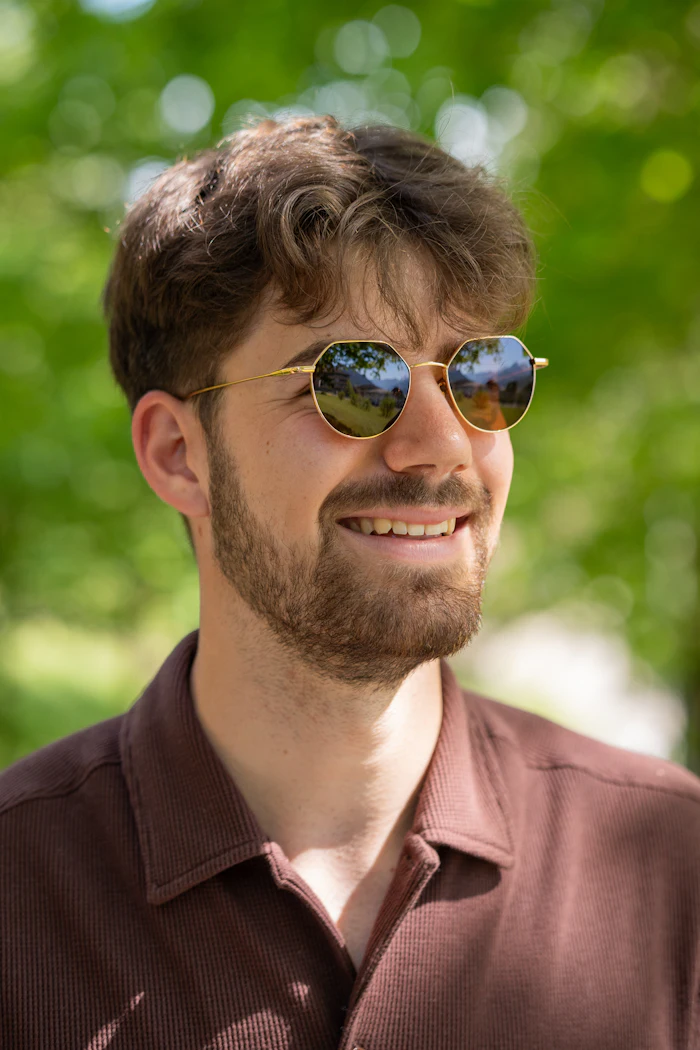 Man in a brown shirt wearing sunglasses